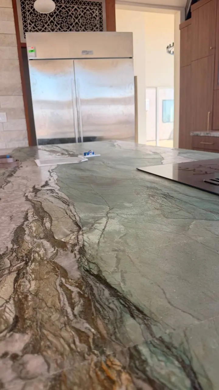 Stone countertop beside a built-in refrigerator