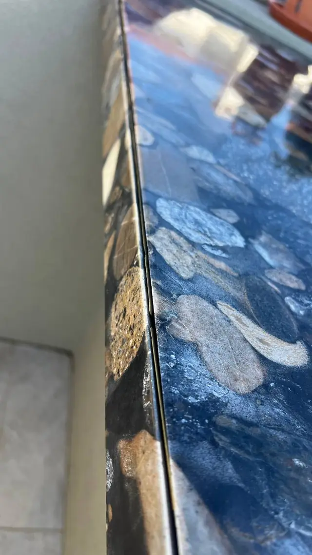 Close-up of a restored stone countertop edge and seam