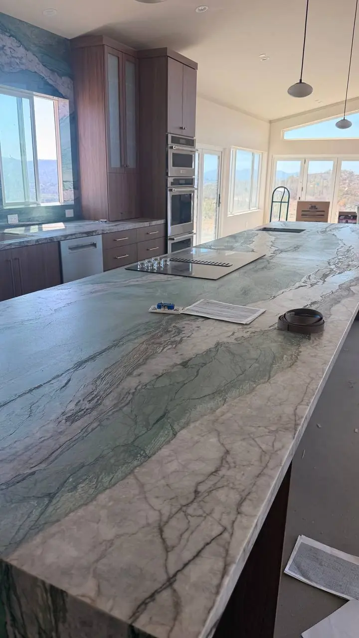 Long stone island beside built-in ovens